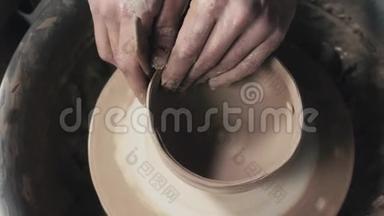 陶工在陶工的车轮上用陶制工具塑造陶制品`顶部视图、色调的电影、工艺工厂